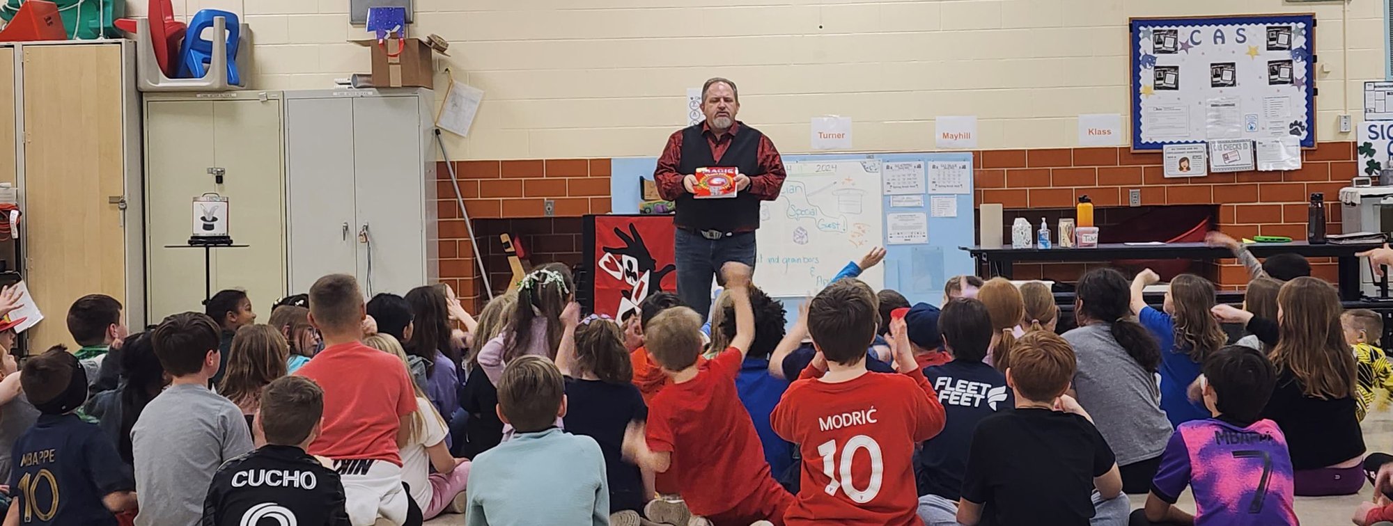 A school gym full of children watching Carroll Baker perform